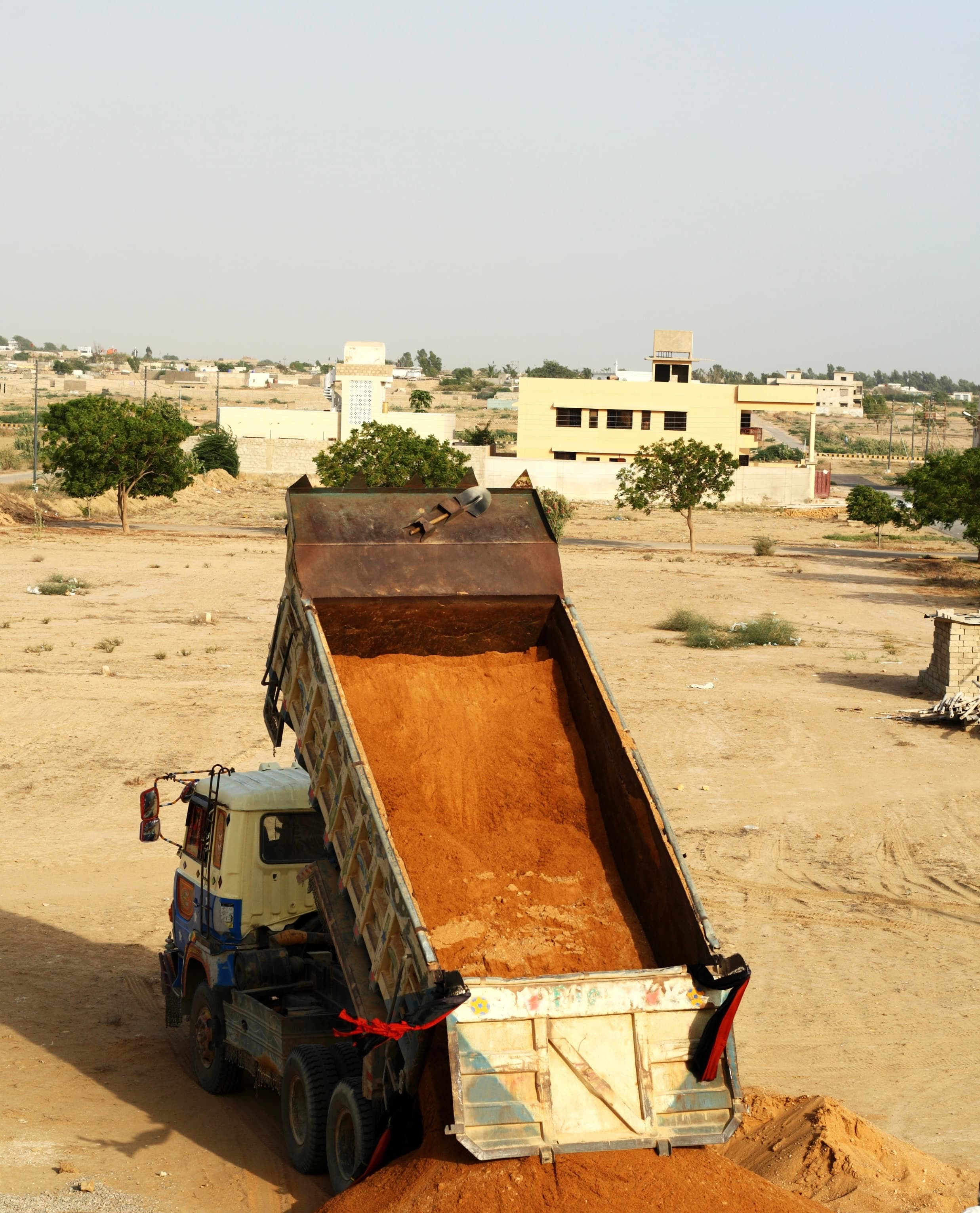 Dump truck delivering sand to construction site